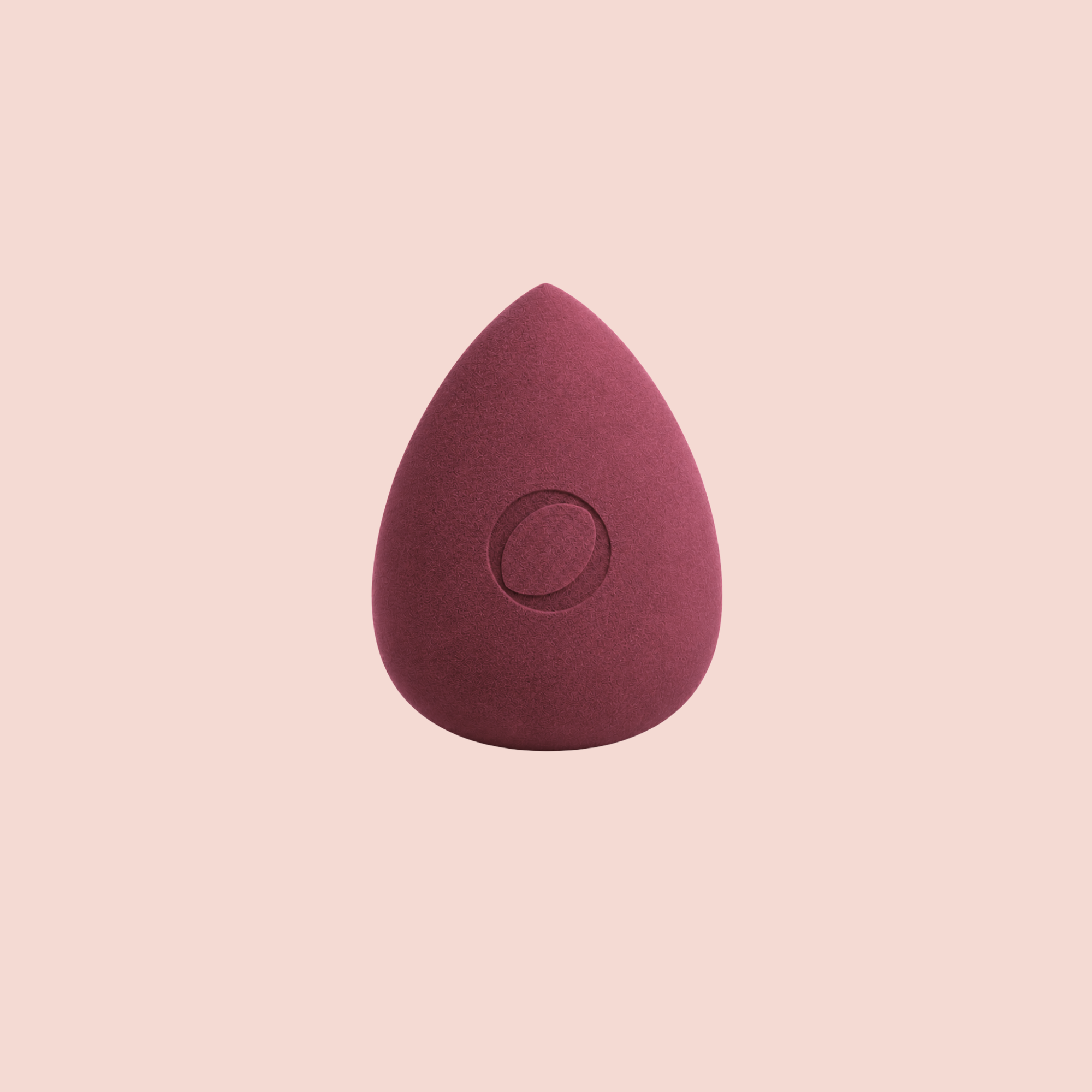 A Aspilon Cosmetics teardrop-shaped makeup sponge in a burgundy color centered on a solid pale pink background.